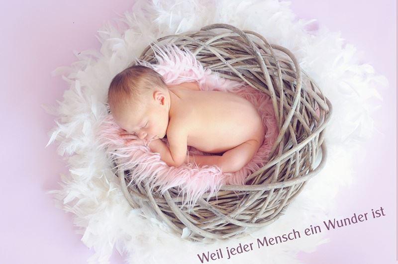 Baby im Weidenkorb rosa Hintergrund